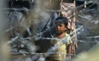 Rohingya refugees gather near the fence in the 'no man's land' between Myanmar and Bangladesh