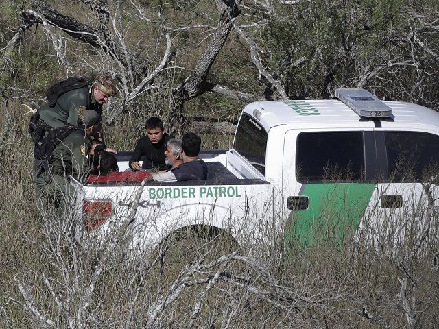 In this Tuesday, Nov. 15, 2016, photo, a U.S. Customs and Border Patrol agents stop a group of suspected illegal immigrants passing through a ranch near Edinburg, Texas. (AP Photo/Eric Gay)