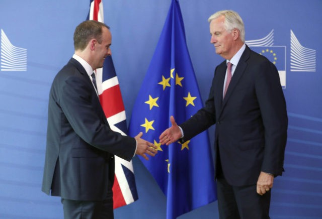 Britain's newly appointed chief Brexit negotiator Dominic Raab, left, is welcomed by