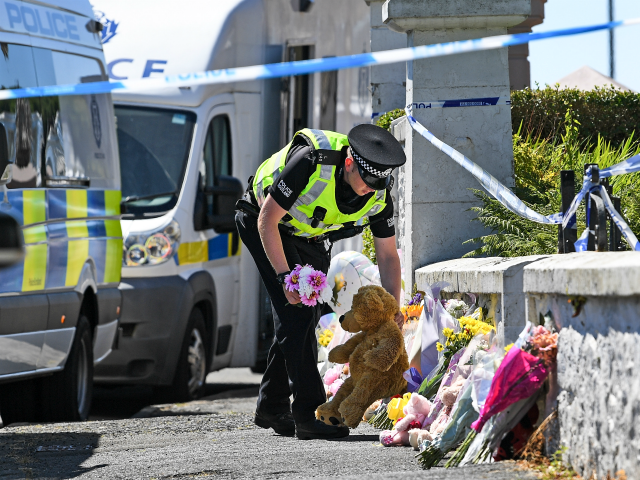 A policeman lay flowers for a member of the public …