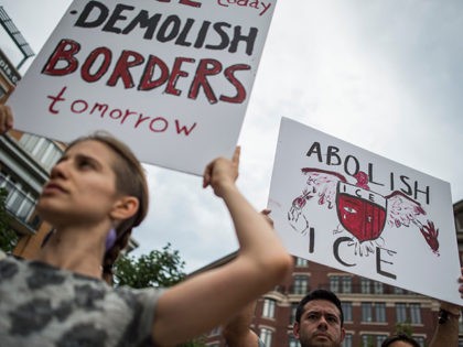 People hold up signs as they protest the US Immigration and Customs Enforcement agency (ICE) and the recent detentions of illegal immigrants in Washington, DC on July 16, 2018. - The coalition of activists called on the government to abolish ICE.