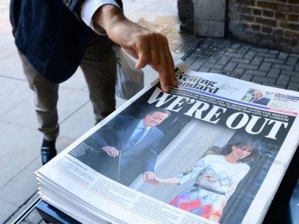 A man takes a copy of the London Evening Standard with the front page reporting the resignation of British Prime Minister David Cameron and the vote to leave the EU in a referendum, showing a pictured of Cameron holding hands with his wife Samantha as they come out from 10 …