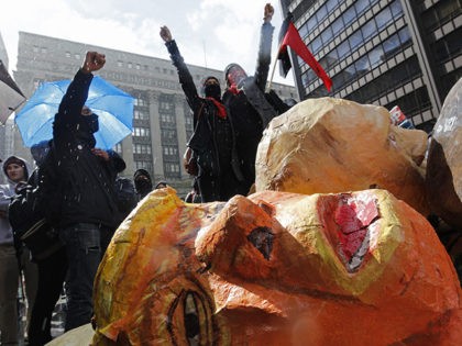 Protestors cheer over a destroyed papier-mache head of US President Donald Trump during Ma