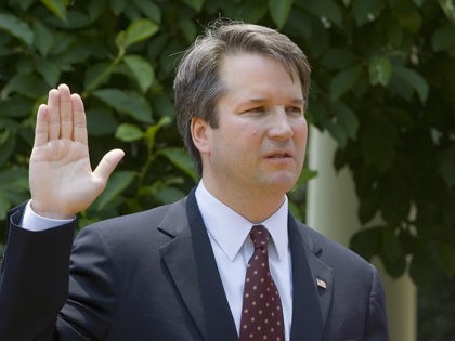 Washington, UNITED STATES: Brett Kavanaugh (L) is sworn in as a US Court of Appeals Judge for the District of Columbia by US Supreme Court Justice Anthony Kennedy (R) as Kavanaugh's wife Ashley (C) holds the Bible during ceremonies 01 June 2006 in the Rose Garden of the White House …