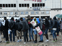 GettyImages-834462514 Migrants wait to board buses as police prepare the evacuation of a makeshift camp at Porte de la Chapelle, in the north of Paris, on August 18, 2017. More than a thousand migrants and refugees were evacuated on early August 18 from a makeshift camp that had been set up …