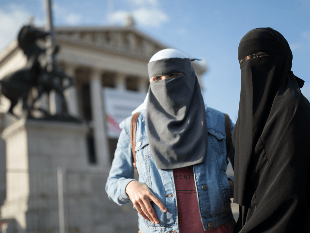 Women wearing a traditonal hijab headdress protest against Austria's ban on full-face