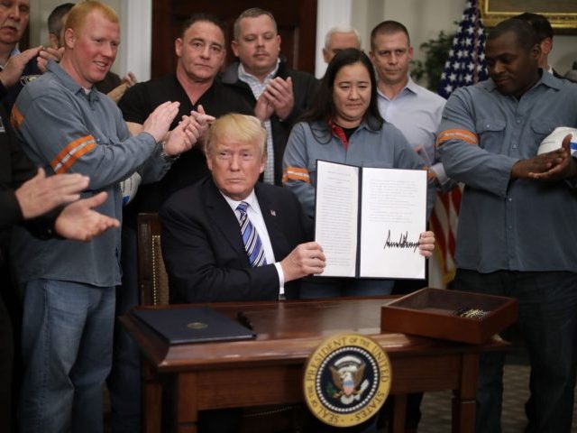 WASHINGTON, DC - MARCH 08: Surrounded by applauding steel and aluminum workers, U.S. President Donald Trump holds up the 'Section 232 Proclamations' on steel imports that he signed in Roosevelt Room the the White House March 8, 2018 in Washington, DC. Trump announced last week that he will put a …