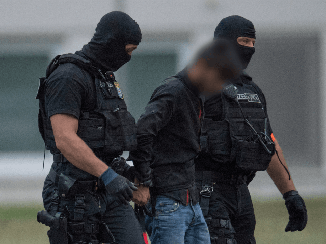 Police officers of a special unit escort Iraqi asylum seeker Ali Bashar, who is suspected of having killed a German teenage girl, from a helicopter to the police headquarters in Wiesbaden, western Germany, after he was flown back from Erbil to Germany on June 9, 2018. - The 20-year-old man …