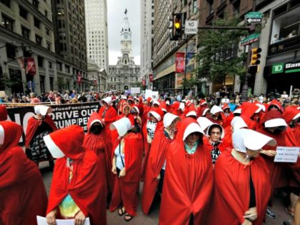 Protesters, in view of City Hall, center, dressed as characters from "The Handmaid's Tale," demonstrate against Vice President Mike Pence's visit to the Union League in Philadelphia, Monday, July 23, 2018.