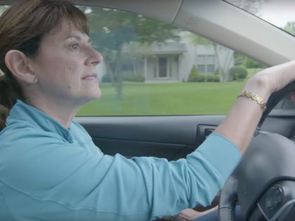 Leah Vukmir appears in a campaign ad driving a car with a blurred Toyota logo.