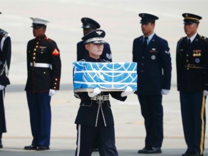 A soldier carries a casket containing a remain of a U.S. soldier who were killed in the Ko