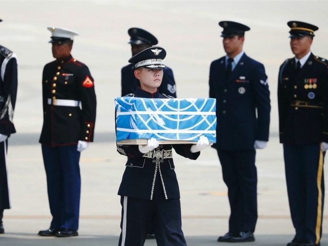 A soldier carries a casket containing a remain of a U.S. soldier who were killed in the Ko