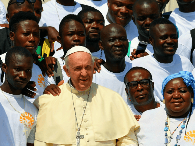 TOPSHOT - Pope Francis poses for photographs during a meeting with a group of migrants at