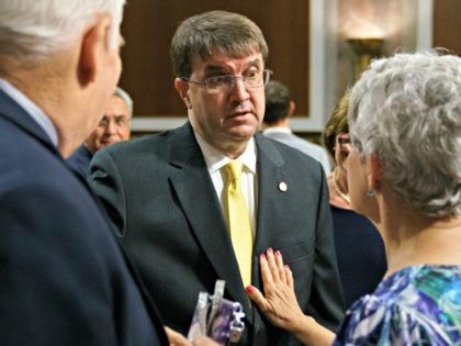 Veterans Affairs Secretary nominee Robert Wilkie, center, talks with John Wells, left, and Susan Belanger, both of Military Veterans Advocacy, before the start of a Senate Veterans Affairs Committee nominations hearing on Capitol Hill in Washington, Wednesday, June 27, 2018.