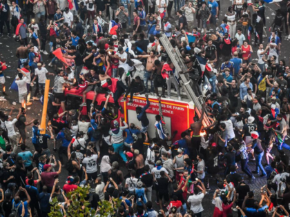 This picture taken from the terrace of the Publicis drugstore on July 15, 2018 shows people standing on a firefighter vehicle after France won the Russia 2018 World Cup final football match between against Croatia, on the Champs-Elysees avenue in Paris.