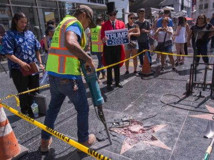 A worker removes the remains of the Star of US President Donald J. Trump on the Hollywood Walk of Fame after it was destroyed by a vandal in the early morning hours on July 25, 2018 in Los Angeles, California. (Photo by DAVID MCNEW / AFP) (Photo credit should read …