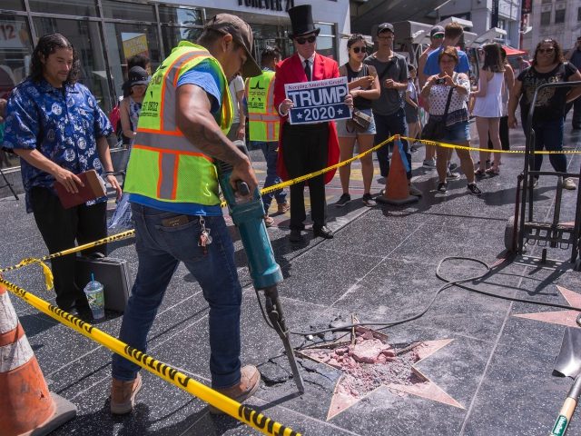 A worker removes the remains of the Star of US President Donald J. Trump on the Hollywood