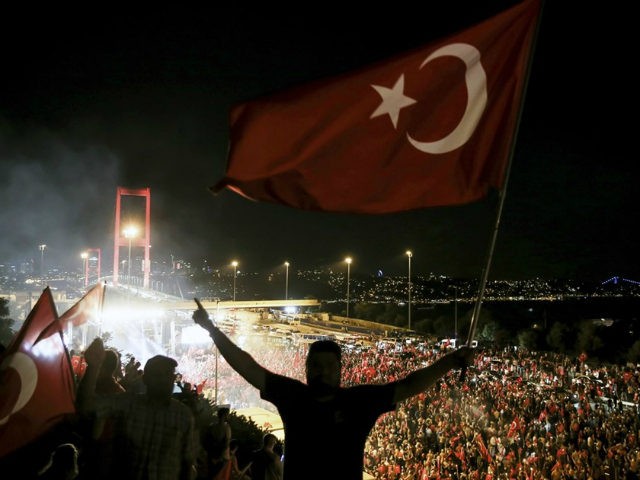 Citizens wave Turkish Flags during a march towards July 15 Martyrs' Bridge to protest Para