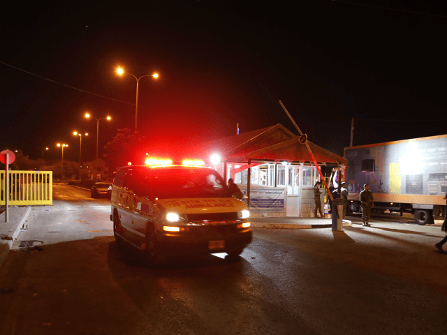 Israeli security forces stand guard as an ambulance carrying victims of a stabbing attack leaves the Adam settlement in the occupied West Bank on July 26, 2018. - Three Israelis were wounded in a knife attack in a West Bank settlement close to Ramallah, the Israeli army said. (Photo by …