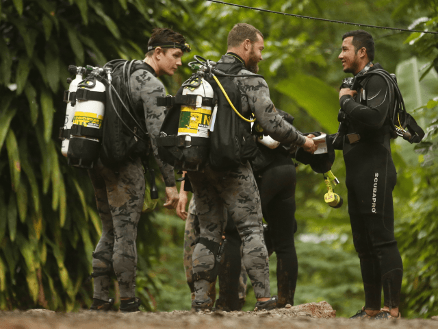 Australian Federal Police and Defense Force personnel talk to a Thai rescuer, right, befor