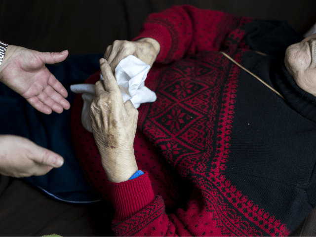 Doret Kohl (L), nurse of the German Red Cross (DRK, or Deutsches Rotes Kreuz) attends to a patient in the geriatric day care facility at Villa Albrecht on March 18, 2013 in Berlin, Germany. A great number of senior Citzens struggle with various forms of dementia at Villa Albrecht. The …