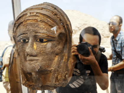 A photographer films a gilded silver mummy mask found on the face of the mummy of the second priest of Mut, as it is displayed during a press conference in front of the step pyramid of Saqqara, in Giza, Saturday, July 14, 2018. Archaeologists say they have discovered a mummification …