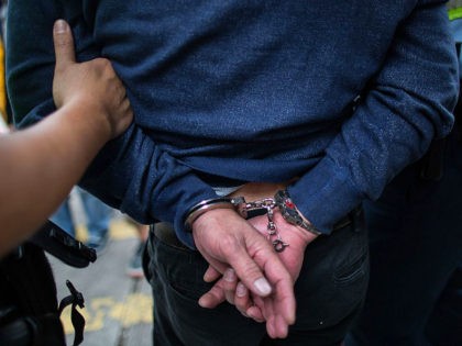 A police officer restrains a man (C) arrested during an anti-parallel trading protest in t