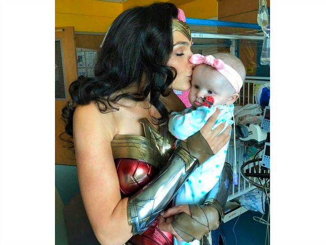 This image released by Kelly Swink Sahady shows Gal Gadot, dressed as Wonder Woman kissing
