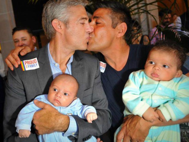 Chris Roe (L) and Roby Chavez (R) celebrate while holding their soon-to-be adopted children as the US Supreme Court ruling is announced on June 26, 2013. The US Supreme Court struck down The Defense of Marriage Act (DOMA) today, and declared that same-sex couples who are legally married deserve equal …