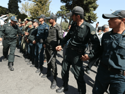 Iranian police stand between supporters of the Basiji militia and supporters of Iranian pr