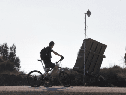 TEL AVIV, ISRAEL - AUGUST 31: (ISRAEL OUT) An Israeli man rides his bicycle past the 'Iron Dome' missile defense system as it is deployed on August 31, 2013 in Tel Aviv, Israel. Tensions are rising in Israel amid international talks of a military intervention In Syria. (Photo by Uriel …