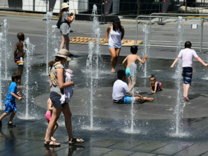 Women and children play in the water fountains at the Place des Arts in Montreal, Canada on a hot summer day July 3, 2018. (Photo by EVA HAMBACH / AFP) (Photo credit should read EVA HAMBACH/AFP/Getty Images)