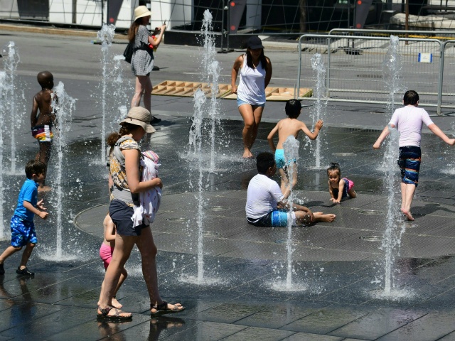 Women and children play in the water fountains at the Place des Arts in Montreal, Canada o