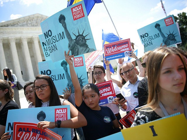 WASHINGTON, DC - JUNE 26: Protesters hols up signs that read 'No Muslim ban' against U.S. President Trump's travel ban gather outside the U.S. Supreme Court as the court issued an immigration ruling June 26, 2018 in Washington, DC. The court issued a 5-4 ruling upholding U.S. President Donald Trump's …