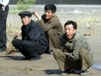 north korea North Koreans squat on mudflats at the North Korean town of Sinuiju, opposite the Chinese city of Dandong Friday April 23, 2004. Despite their countries' ostensible friendship, the mood at the border is tense and dour, and the contrast between China's relative wealth and openness and North Korea's poverty and …