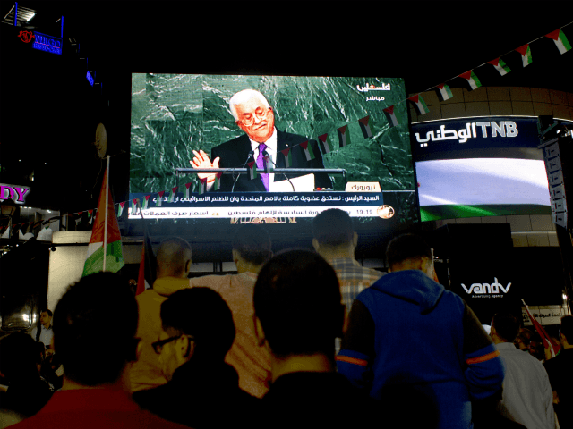 Palestinians watch a speech by Palestinian President Mahmoud Abbas at the U.N. General Ass