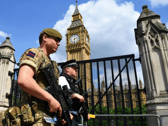 TOPSHOT - A British Army soldier patrols with an armed police officer near the Houses of P