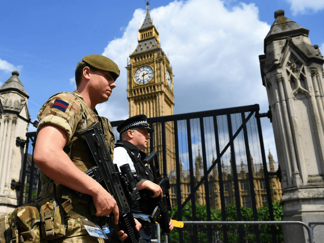 TOPSHOT - A British Army soldier patrols with an armed police officer near the Houses of Parliament in central London on May 24, 2017. Britain deployed soldiers to key sites Wednesday and raised its terror alert to the maximum after the Manchester suicide bombing by Salman Abedi, reportedly a Briton â¦