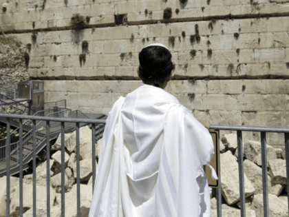 Observing Jew looks at the part f the Western Wall where one of the stones dislodged and c