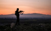 A Syrian rebel fighter aims his Kalashnikov assault rifle near the frontline outside the southern city of Daraa on July 3, 2018