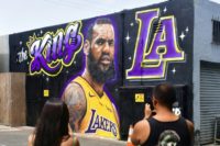 People photograph a mural of LeBron James in a Los Angeles Lakers jersey painted by Jonas Never and Menso One in Venice, California to welcome James to his new team