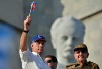 President Miguel Diaz-Canel waves a Cuban flag as former president Raul Castro looks on during a May Day celebration in Havana