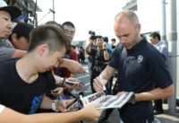 Iniesta signs autographs as he is greeted by Vissel Kobe supporters upon his arrival at the Kansai International airport in Osaka