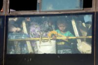 A Syrian child looks through the windows of a bus carrying rebels and their families from the southern province of Quneitra to northern Syria on on July 21, 2018