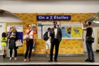 People took pictures of the new sign reading "On a deux etoiles" ("We have two stars") at Etoile metro station