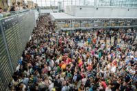 Travellers gather in front of information boards in the Munich airport after hundreds of flights were cancelled and thousands of people evacuated when an unidentified person entered a secure area