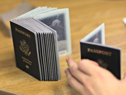 A Passport Processing employee uses a stack of blank passports to print a new one at the Miami Passport Agency