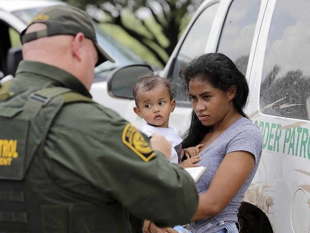 In this Monday, June 25, 2018 file photo, a mother migrating from Honduras holds her 1-year-old child as surrendering to U.S. Border Patrol agents after illegally crossing the border, near McAllen, Texas. As NATO allies convene, one issue not on their formal agenda but never far from their thoughts is …