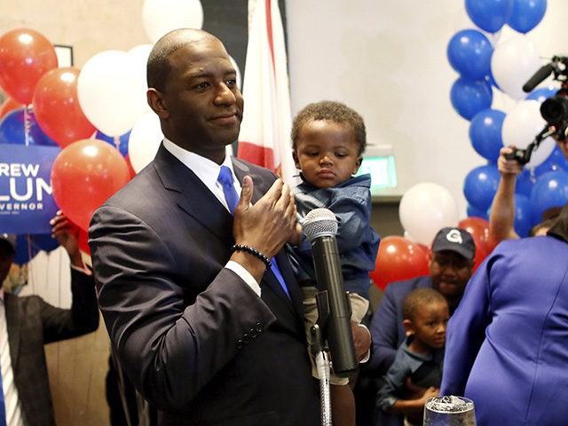 CORRECTS HIS SON'S NAME TO DAVIS, NOT JACKSON - Andrew Gillum holds his son Davis as he addresses his supporters after winning the Democrat primary for governor on Tuesday, Aug. 28, 2018, in Tallahassee, Fla. (AP Photo/Steve Cannon)