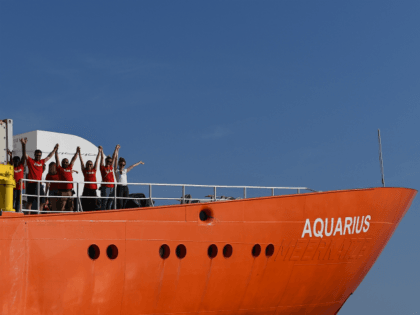 Crew members wave as the rescue ship Aquarius, chartered by French aid group SOS Mediterra